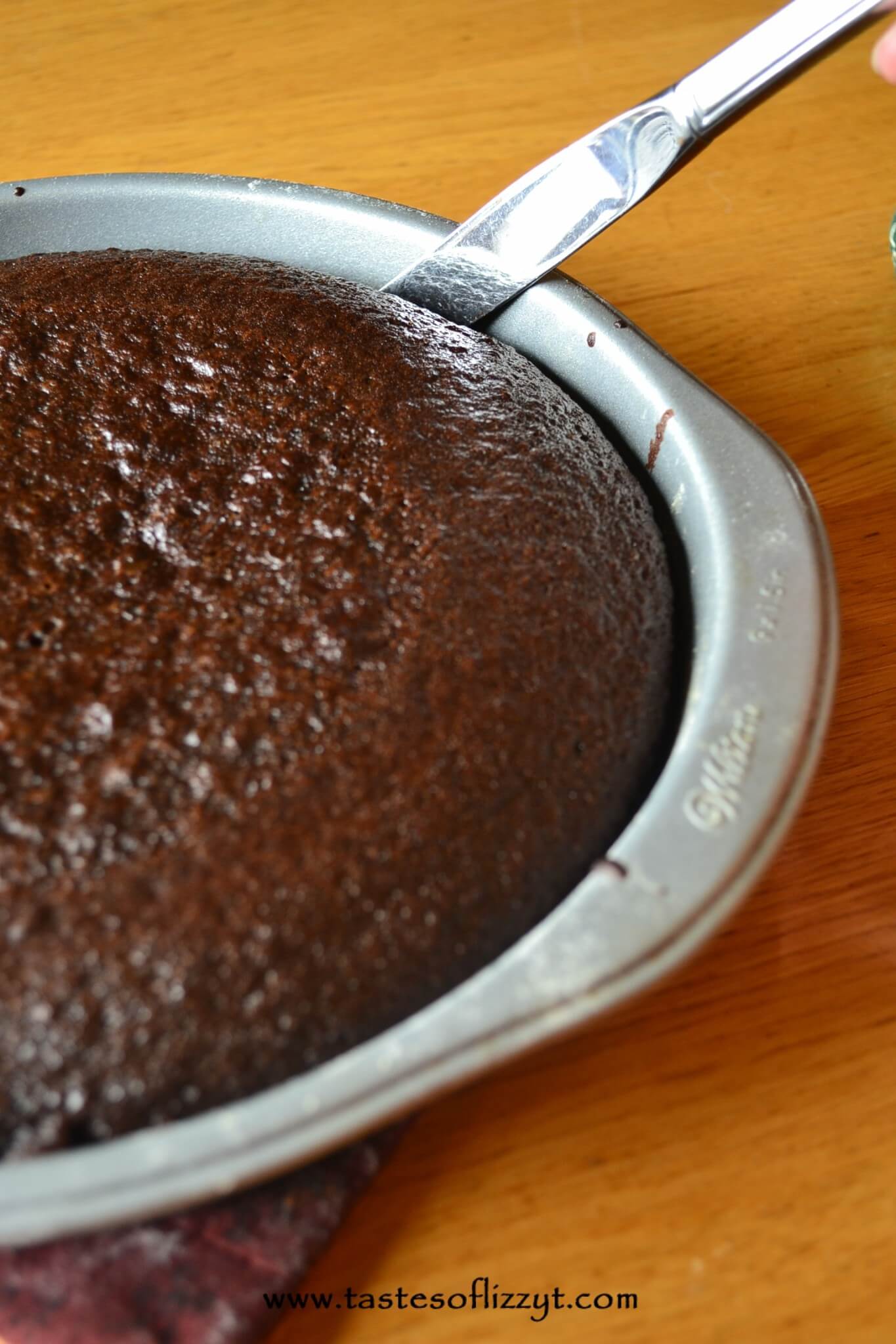 using a knife to get a chocolate cake out of a pan