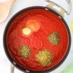 tomato puree in a pan with seasoning