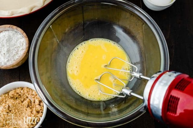 eggs in a mixing bowl with a red mixer