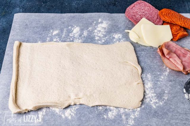 pizza dough pressed out on paper