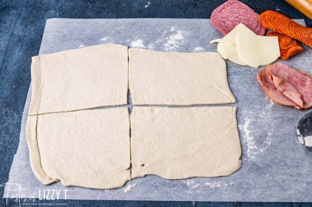 pizza dough pressed out on paper and cut