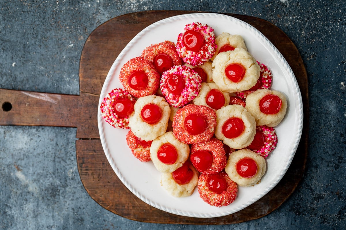 cream cheese cookies with cherries on a plate on a table