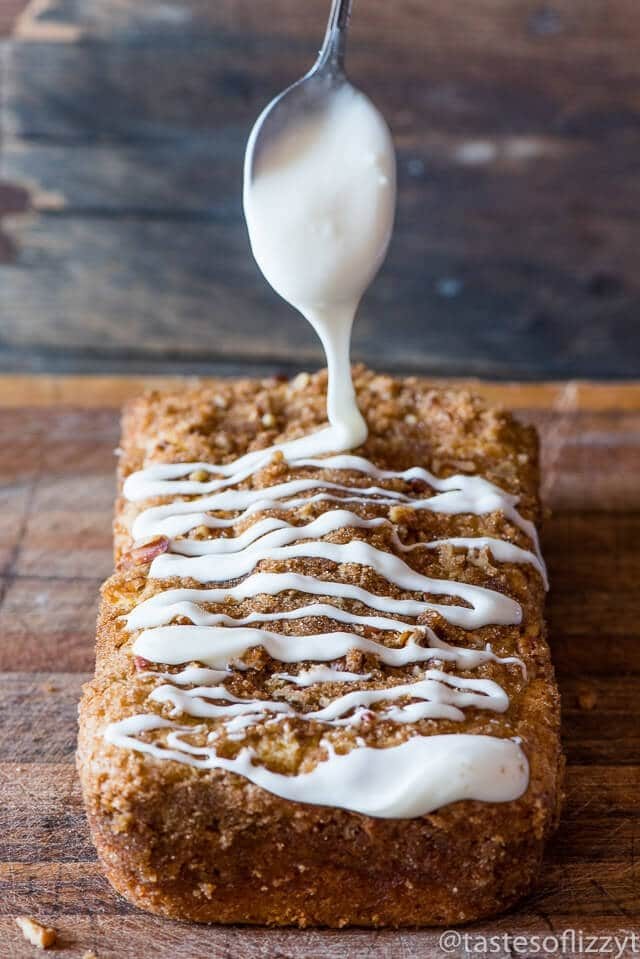 a spoon drizzling powdered sugar glaze on pistachio bread