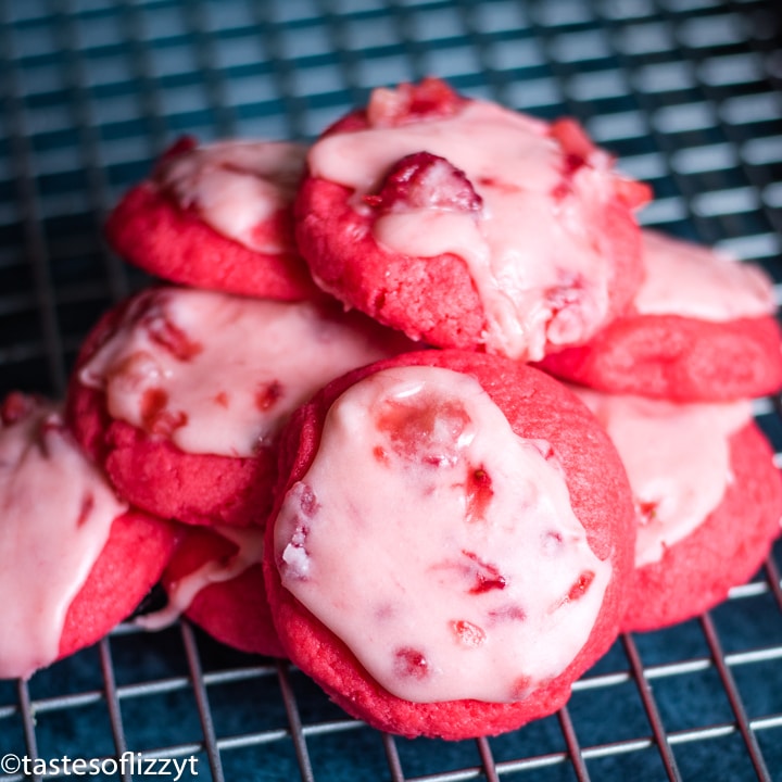 frosted strawberry cookies on a wire rack