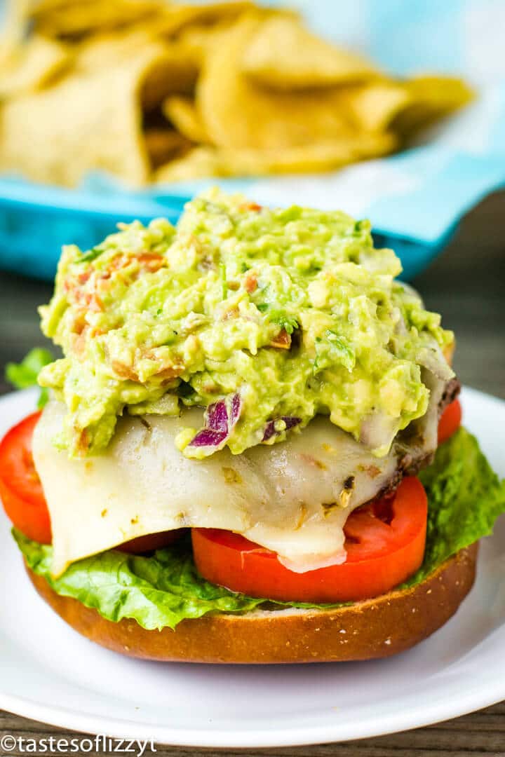 A close up of a burger on a plate, with Guacamole