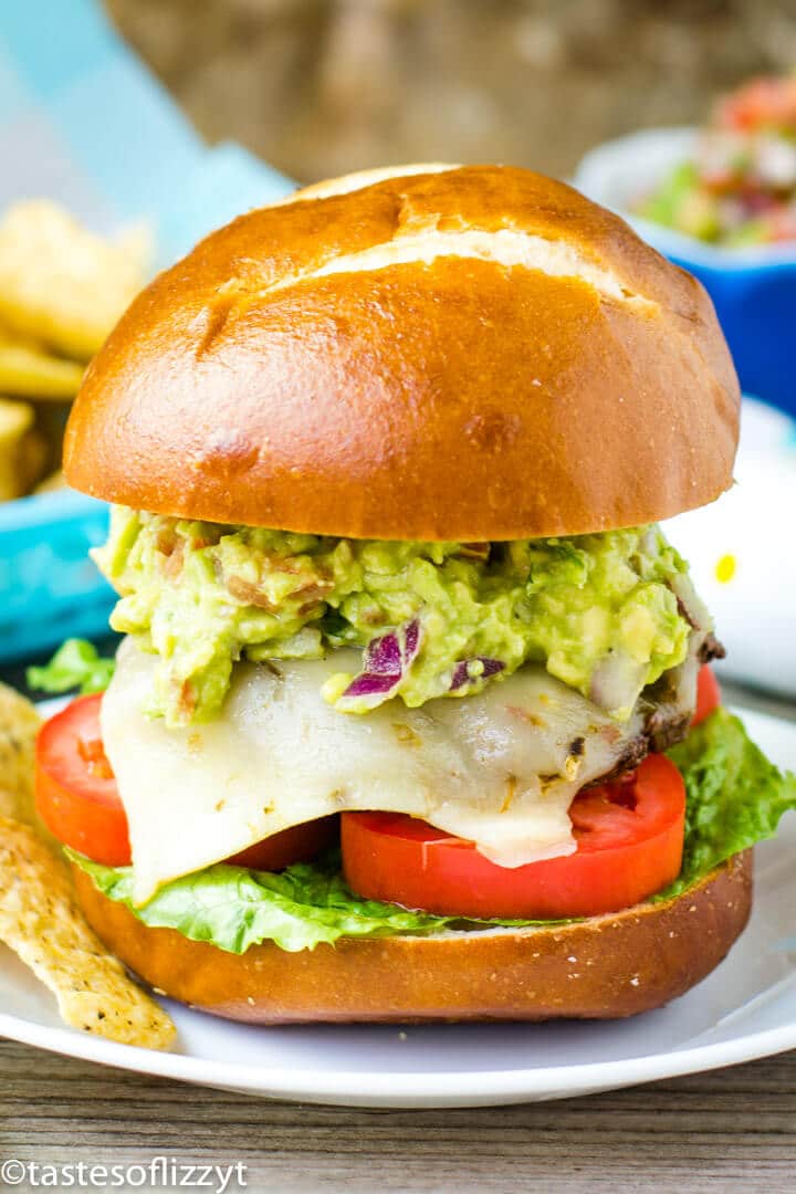 A sandwich with lettuce and fries on a plate, with Guacamole