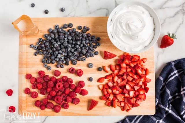 blueberries, raspberries and strawberries on a cutting board