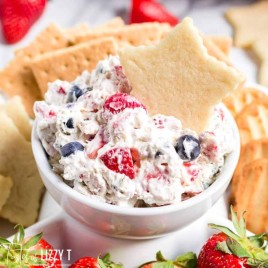 white bowl of triple berry fruit dip with a star cut out cookie
