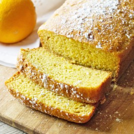 loaf of orange yogurt quick bread with two slices cut