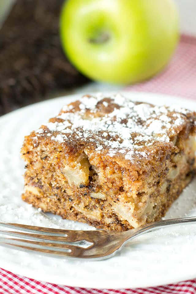 slice of apple walnut cake on a plate with a fork