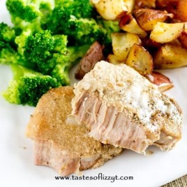 fork tender pork chop on a plate with potatoes and broccoli