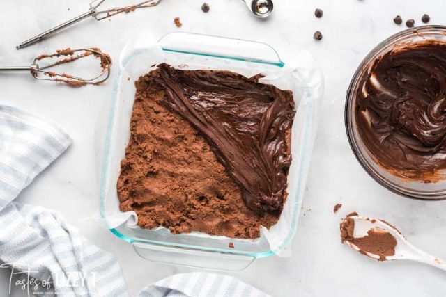 spreading chocolate on nutella fudge in a baking pan