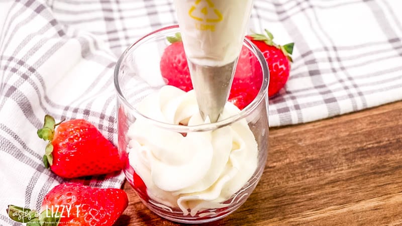 piping whipped cream into a glass