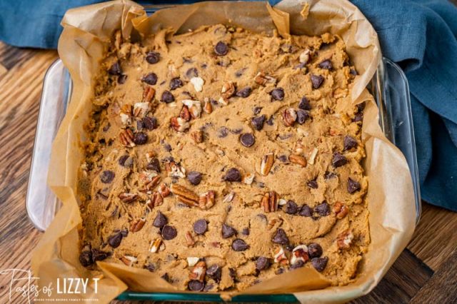 unbaked cookie bars in a parchment lined pan