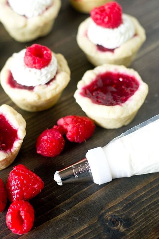 Raspberry Tart with Mascarpone Cream. Bite-size sweet treats with a homemade raspberry pie filling and light cream on top.