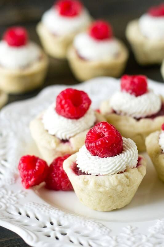 Raspberry Tart with Mascarpone Cream. Bite-size sweet treats with a homemade raspberry pie filling and light cream on top.