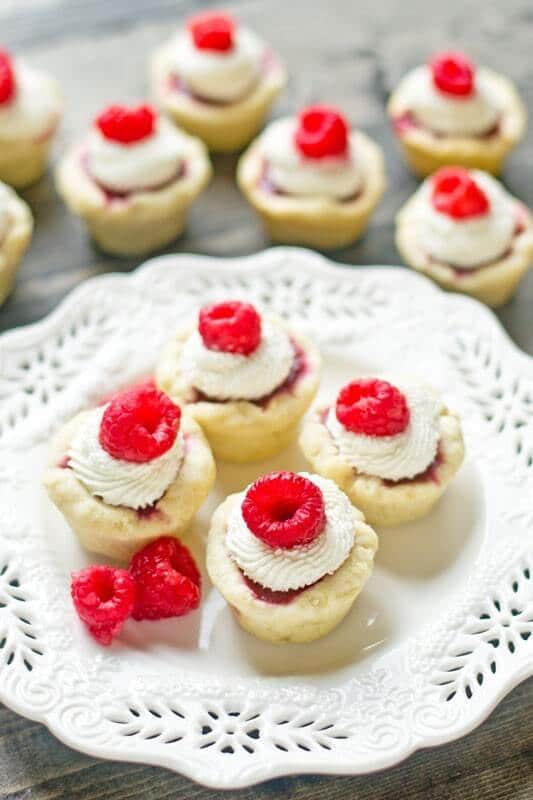 Raspberry Tart with Mascarpone Cream. Bite-size sweet treats with a homemade raspberry pie filling and light cream on top.