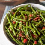 Christmas green beans are dressed up with pimentos and chopped pecans that are caramelized in butter and honey. A simple side dish to complete your dinner. Christmas Green Beans with Toasted Pecans #christmas #vegetables #recipe
