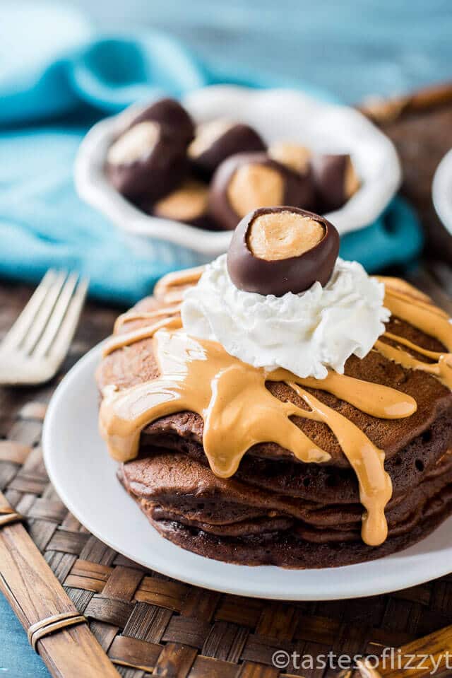 Chocolate Peanut Butter Pancakes {Buckeye Pancakes} Peanut butter buckeye candy filling is cooked inside these fluffy chocolate pancakes. Drizzle with peanut butter and top with whipped cream and a buckeye candy. A perfect Ohio State party recipe!