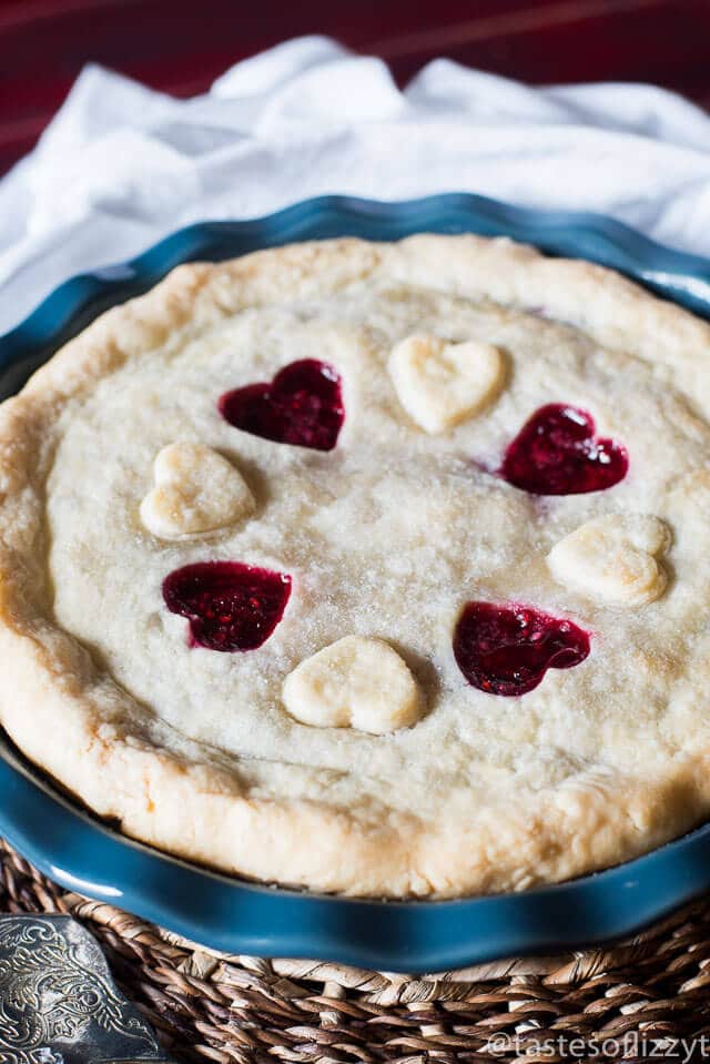 a raspberry pie with red hearts on top