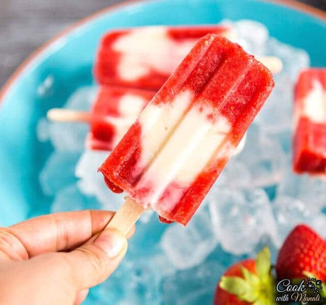 hand holding a strawberry popsicle