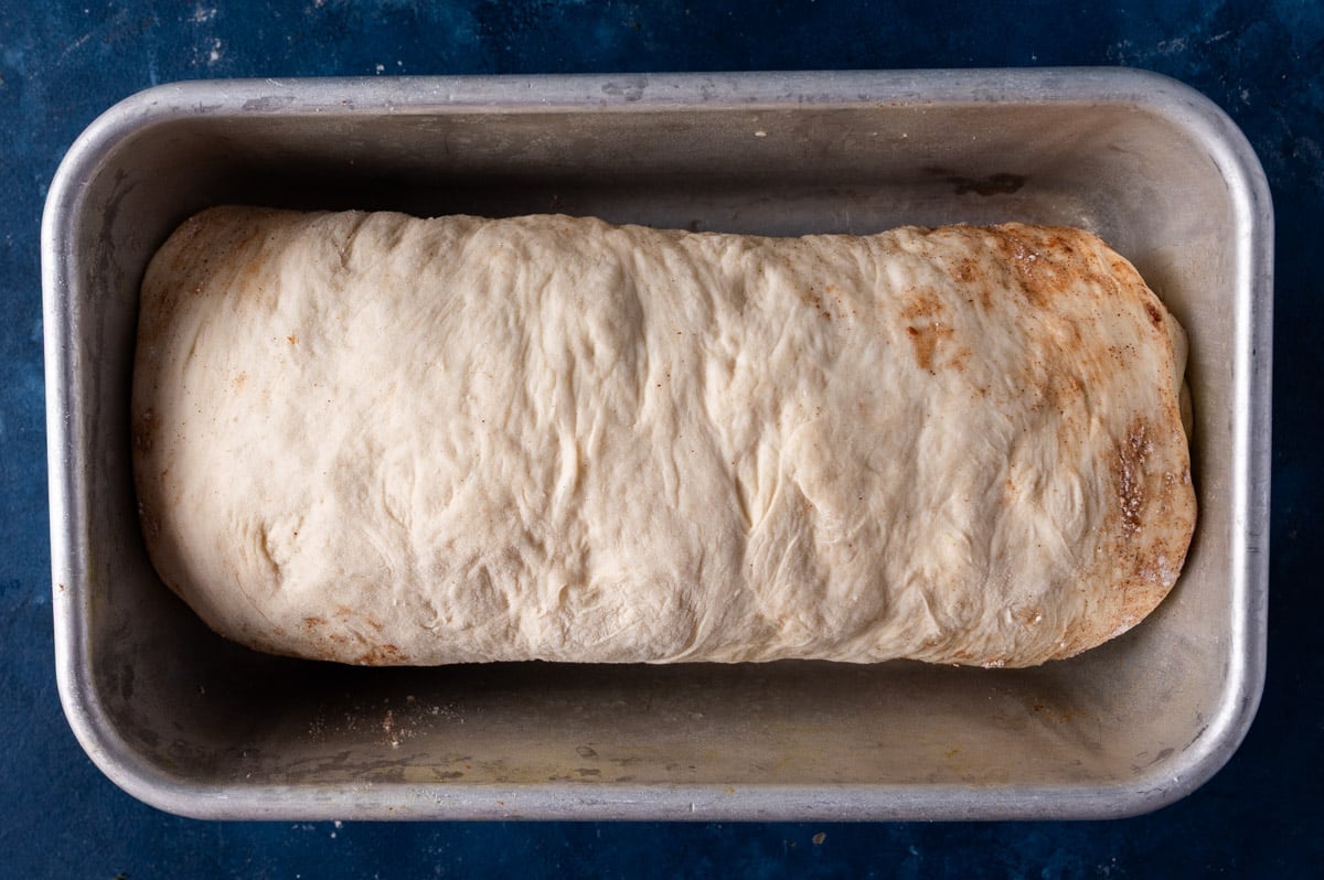 an unbaked loaf of cinnamon bread in a pan before rising