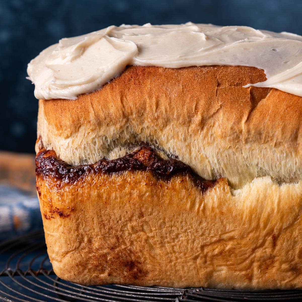 a loaf of homemade cinnamon swirl bread on a wire rack
