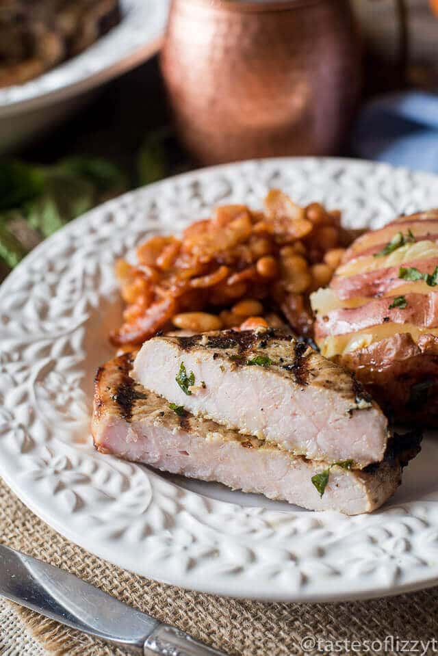 grilled pork chop cut in half on a plate so the juicy center is showing