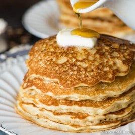 stack of oatmeal pancakes with butter and syrup