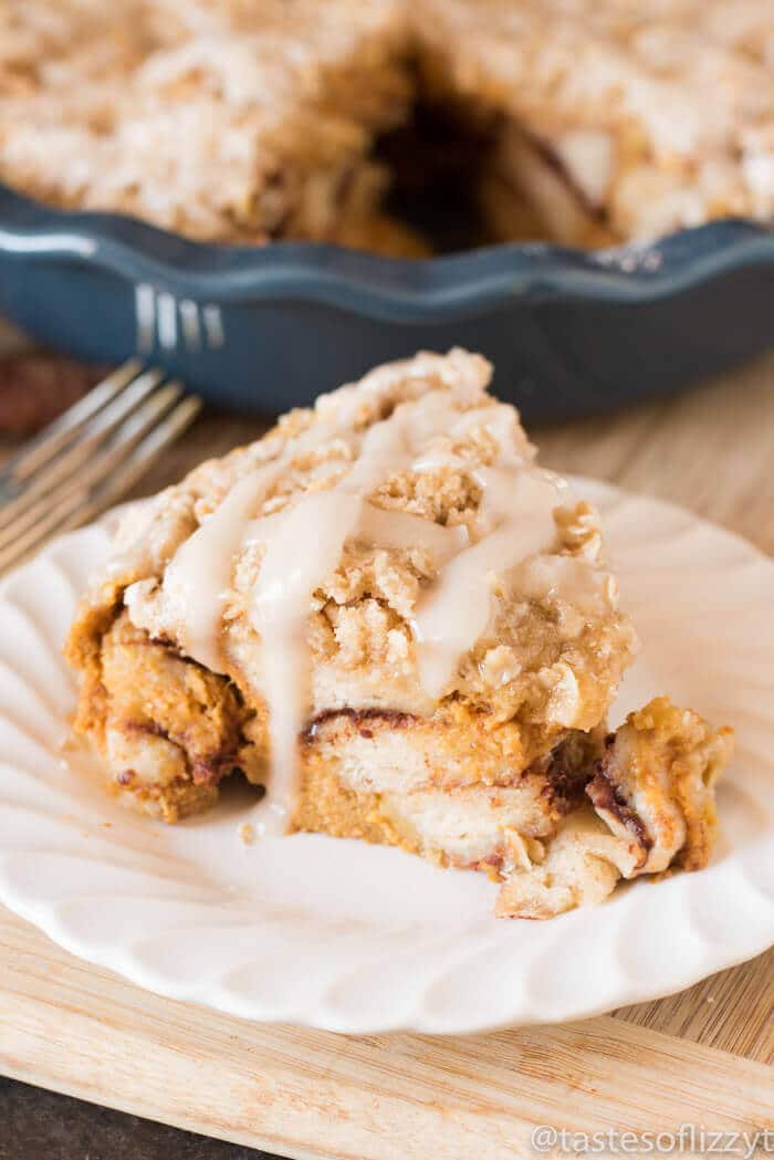 baked pumpkin cinnamon roll with streusel and glaze on top