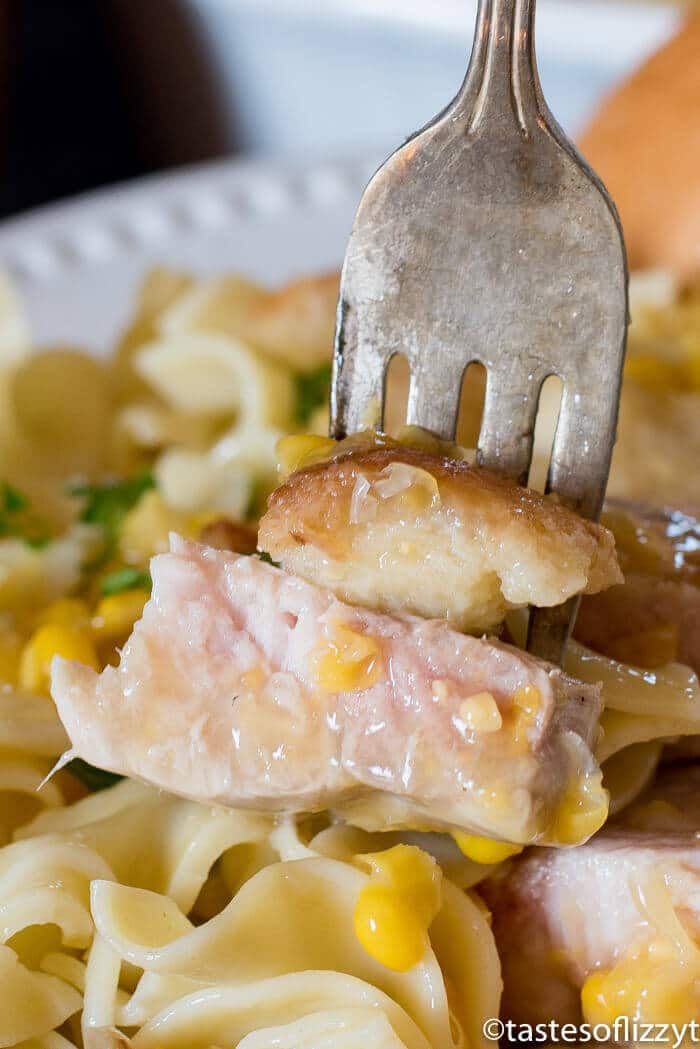 fork holding bites of pork chops casserole with creamed corn