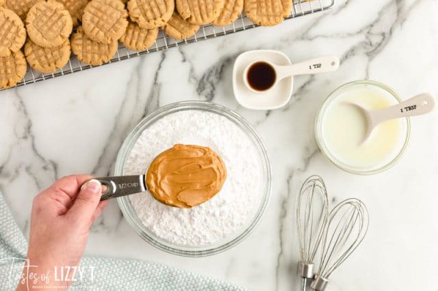 peanut butter in a measuring cup over powdered sugar