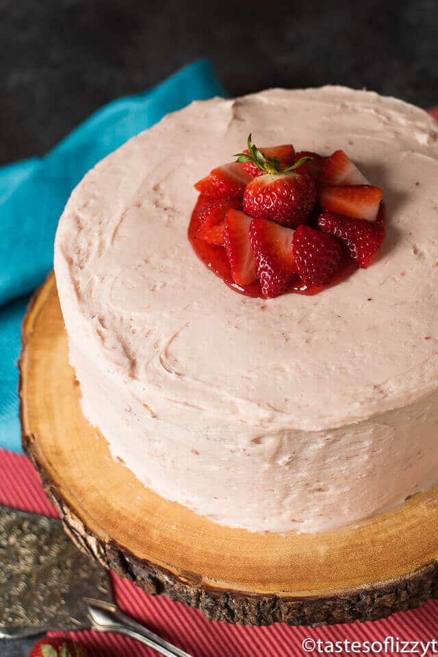 a two layer strawberry cake with fresh sliced strawberries on top