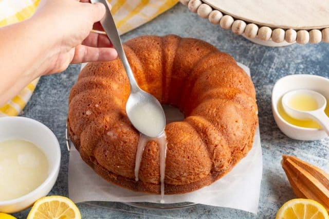 spooning glaze on a bundt cake