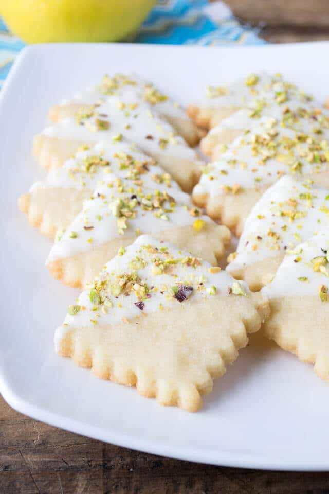 Lemon Shortbread Cookies dipped in white chocolate with pistachios on a plate