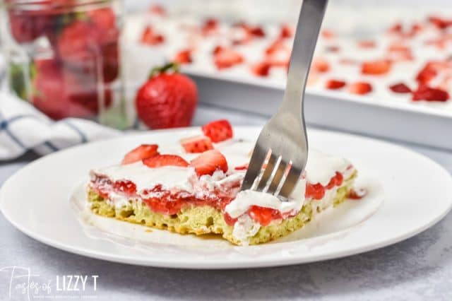 piece of strawberry cake on a plate with a fork