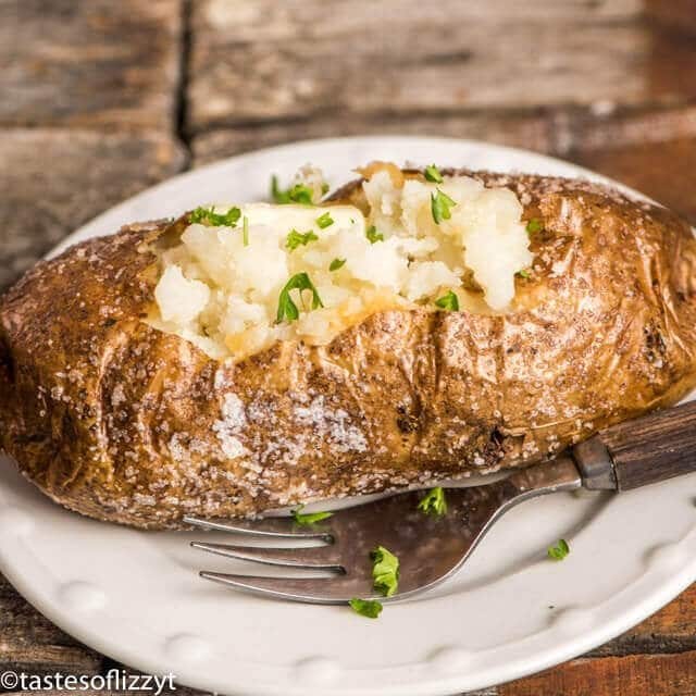 crispy skinned oven-baked potato topped with butter and chives