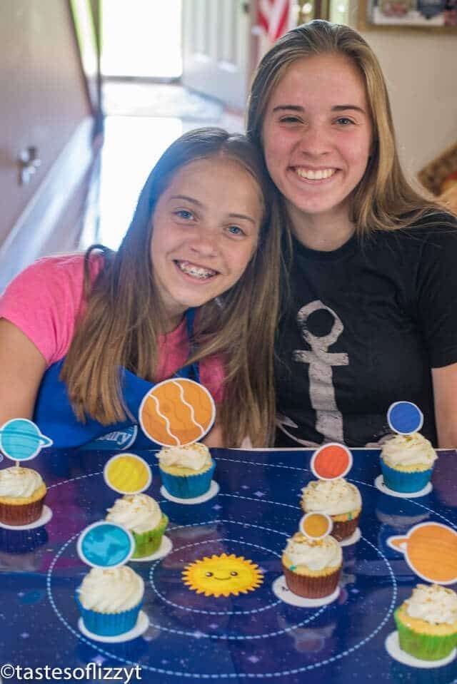 sisters with solar system cupcakes