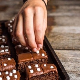 hand placing marshmallows on domino brownies