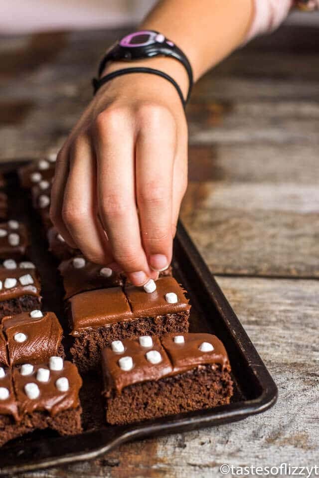 putting marshmallows on domino brownies