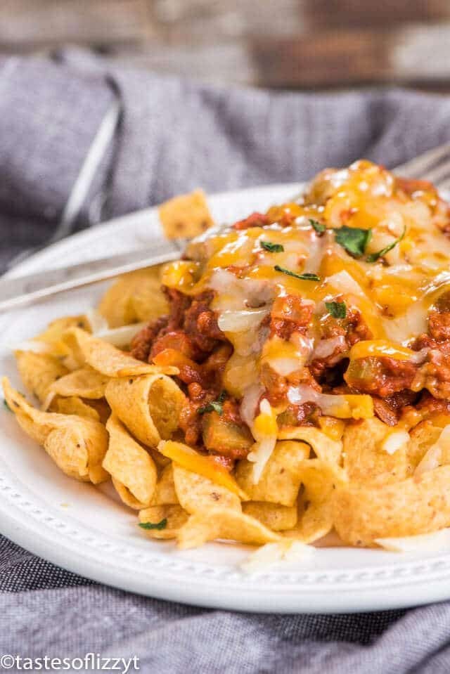 A close up of a plate of food, with chili and fritos