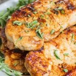 plate of honey oregano pork chops garnished with fresh herbs