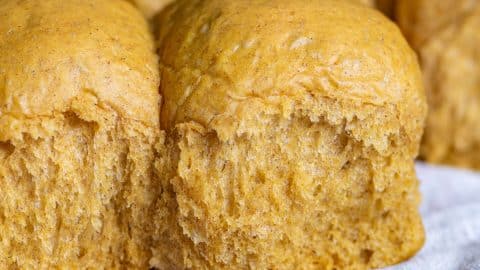 pumpkin dinner rolls on a white piece of paper