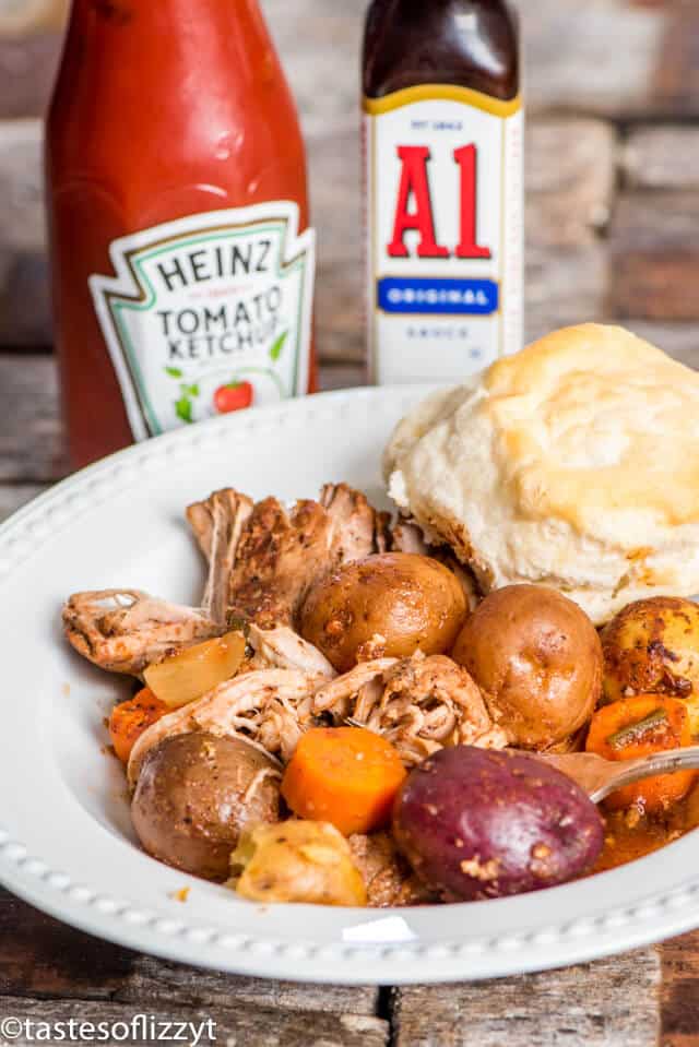 A plate of food and a bottle on a table, with Ketchup