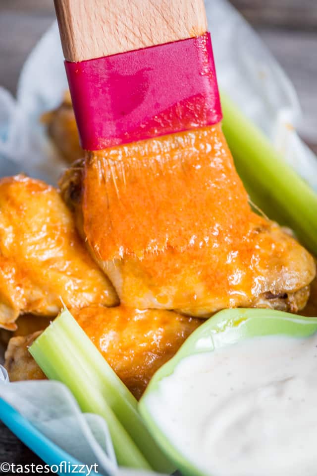 brushing wing sauce on chicken
