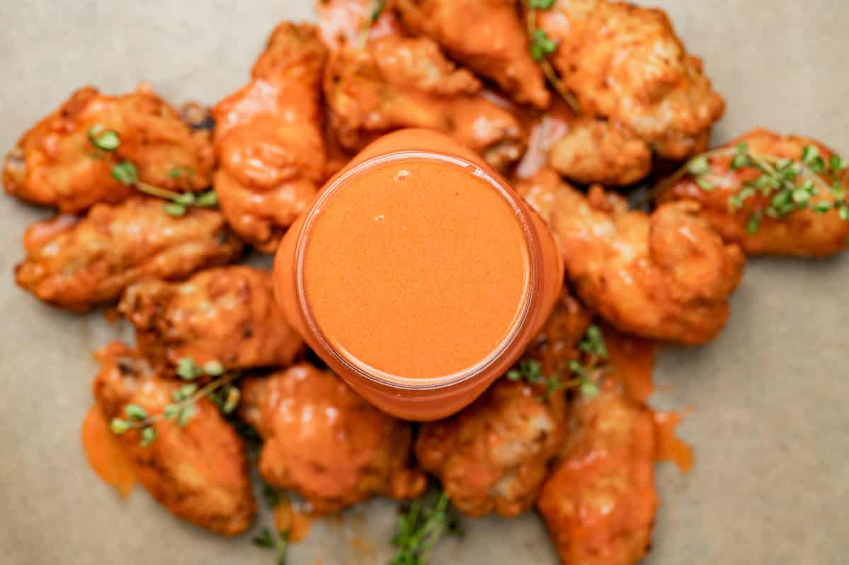 overhead view of buffalo sauce with wings around it