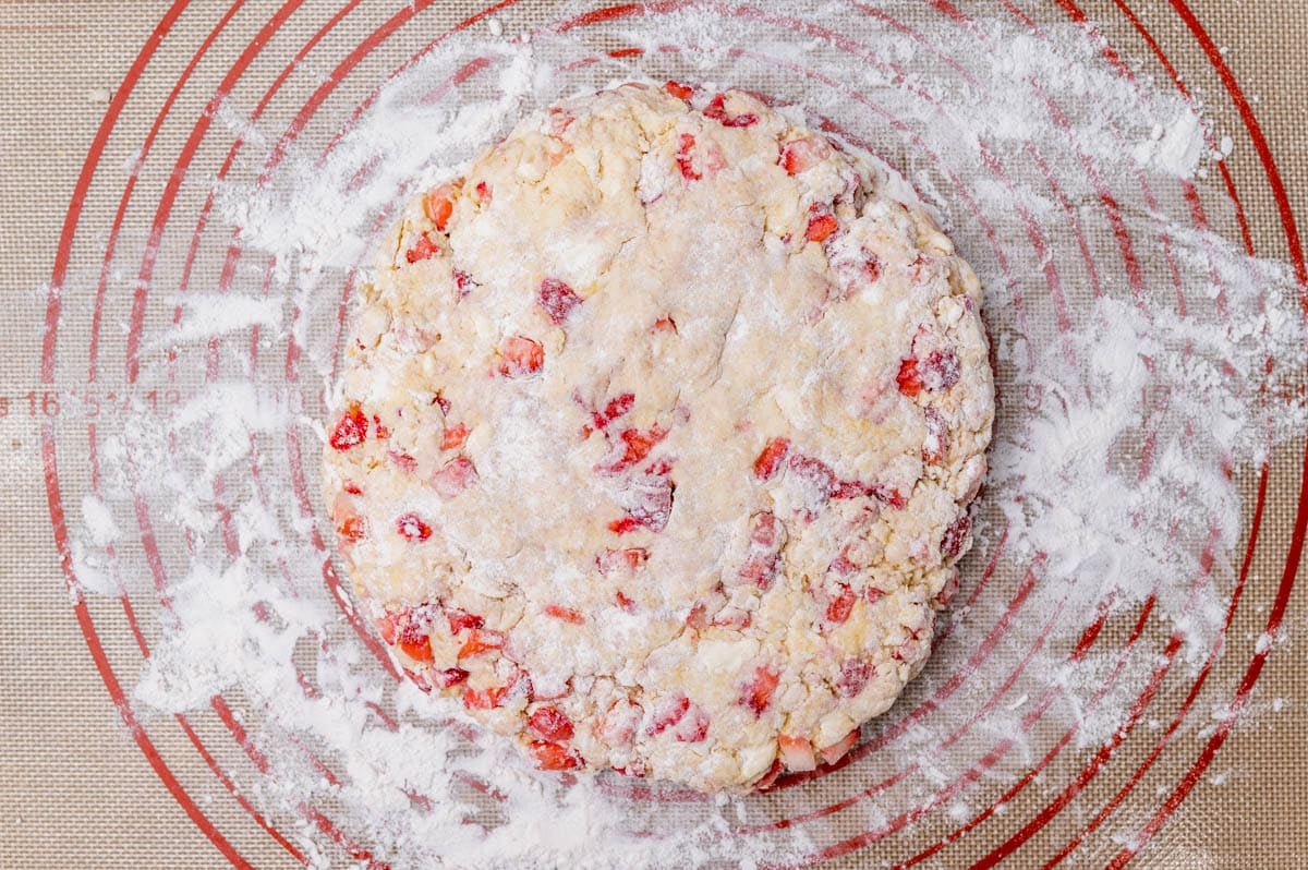 scone dough in a round circle on a floured mat