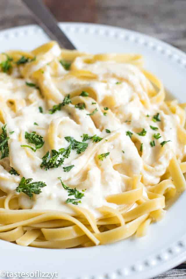 A plate of pasta with sauce and cheese, with Fettuccine