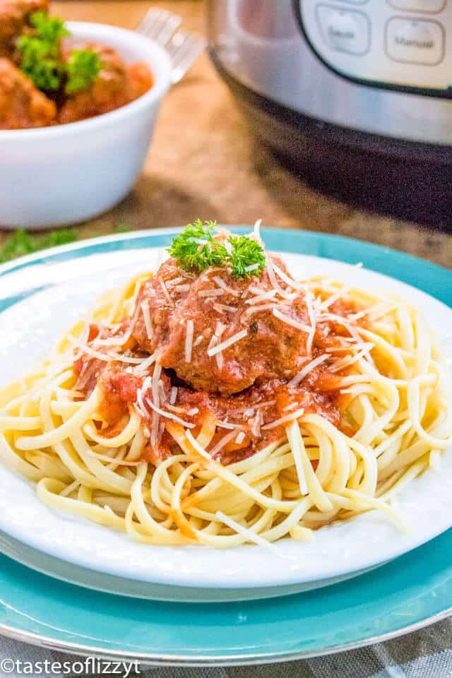 A bowl of pasta sits on a plate, with Meatball and Sauce