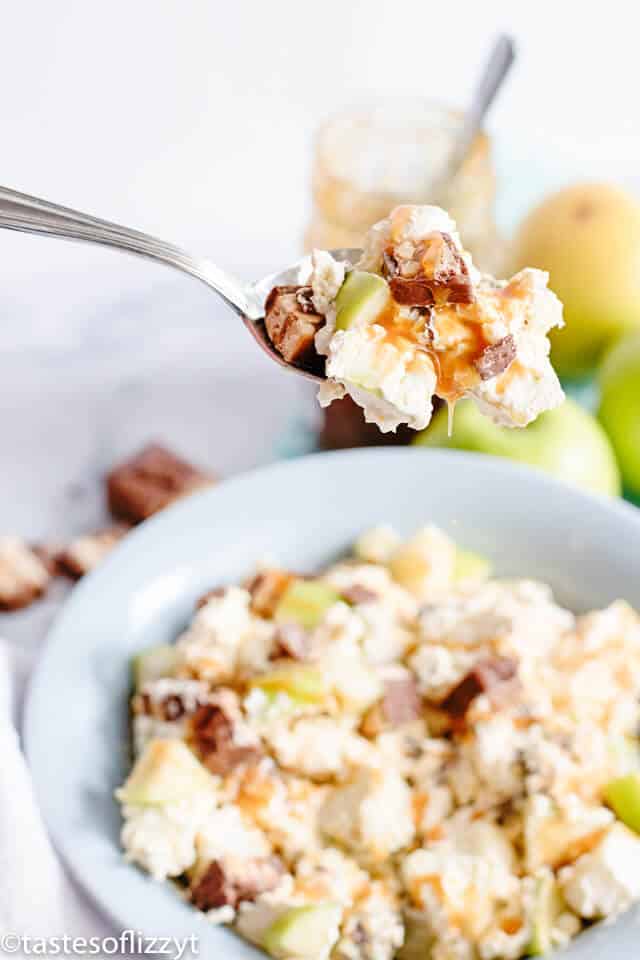 dessert salad made with apples, vanilla pudding and Snickers candy bars